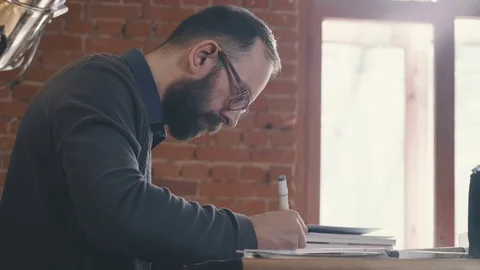 Profile of a man sitting at a table in an office. Designer-architect Stock Footage 73667564
