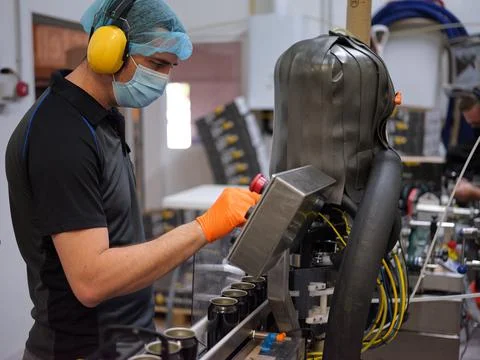 Profile of a man working with an electronic beer canning machine Stock Photos