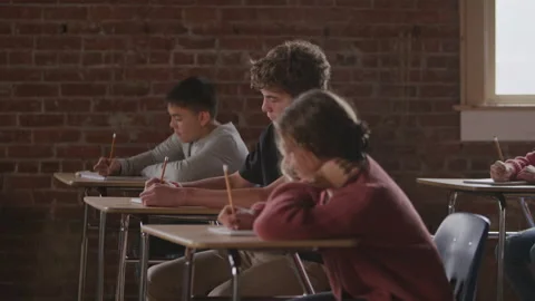 Profile of Middle School Students Taking Notes During Class in Window Light Stock Footage 208796044
