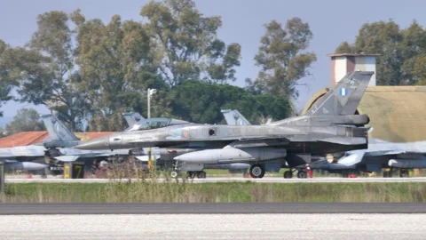 Profile of a NATO grey combat jet plane taxiing with external fuel tanks Vidéo 154882591