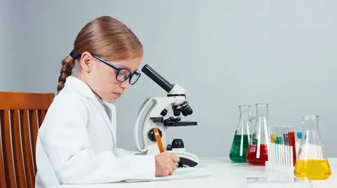 Profile portrait young chemist school girl 7-8 years using microscope Stock Footage 65470514