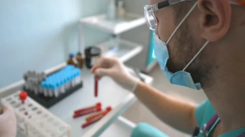 Profile of scientist testing test tube with blood sample to coronavirus. Stock Footage 128590886