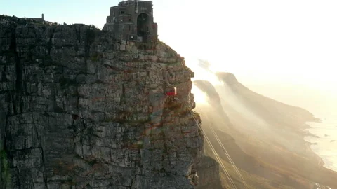 Profile shot of a cable car going up a mountain with a dramatic sunset in the bg Stock Footage 170620583