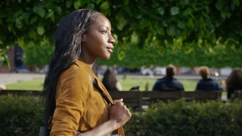 Profile shot of young female walking through town, in slow motion Free Stock Footage 107923853