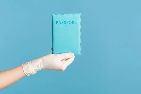 Profile side view closeup of human hand in white surgical gloves holding pass Foto stock