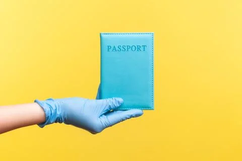 Profile side view closeup of human hand in blue surgical gloves holding passp Foto stock