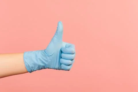 Profile side view closeup of human hand in blue surgical gloves showing like  Foto stock