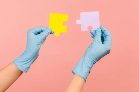 Profile side view closeup of human hand in blue surgical gloves holding yello Foto stock