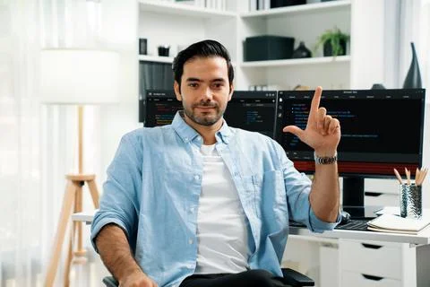 Profile smart IT developer looking camera against on coding pc screen. Surmise. Stock Photos