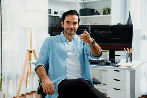 Profile smart IT developer looking camera against on coding pc screen. Surmise. Stockfoto's