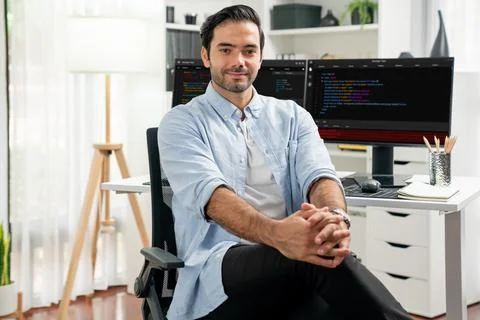 Profile smart IT developer looking camera against on coding pc screen. Surmise. Stock Photos