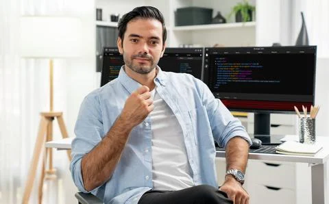 Profile smart IT developer looking camera against on coding pc screen. Surmise. Foto stock