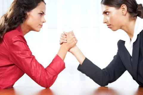 Profile of two women in struggle while their arms being wrestled Stock Photos