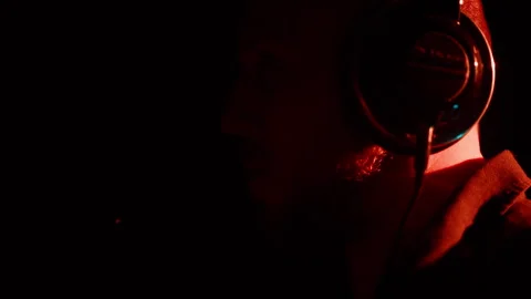 Profile view of a bald, bearded man wearing headphones while singing into a Stock Footage 290152689