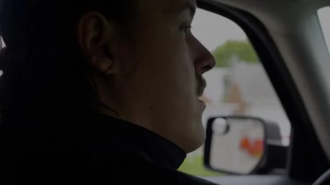 Profile view of a focused driver inside a car, looking out the window... Stock Footage 319881211