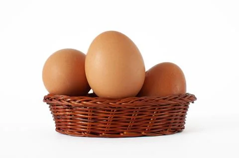 Profile view of fresh, natural brown chicken eggs in mini wicker basket. Stock Photos
