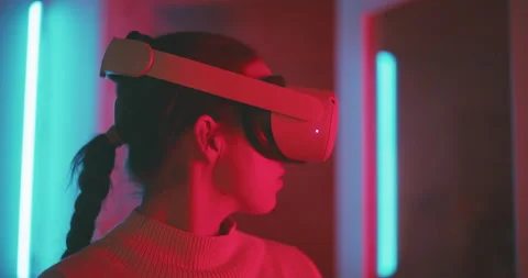 Profile view of a girl trying vr headset in pink and blue neon light Stock Footage 201110147