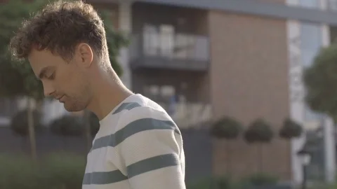 Profile view of handsome young man talking on the phone in town. Видео 70059342