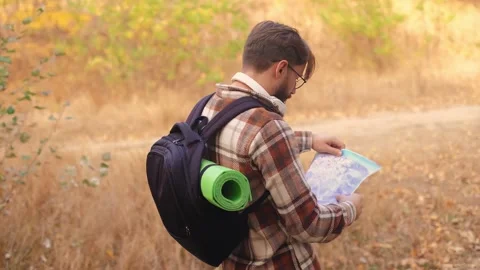 Profile view of man wearing glasses, studying map to navigate outdoor environmen Stock Footage 278277366