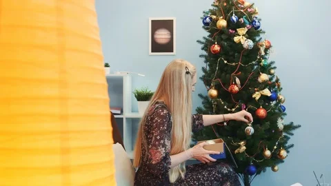 Profile view of nice lady hanging toys on Christmas tree Stock Footage 112345052