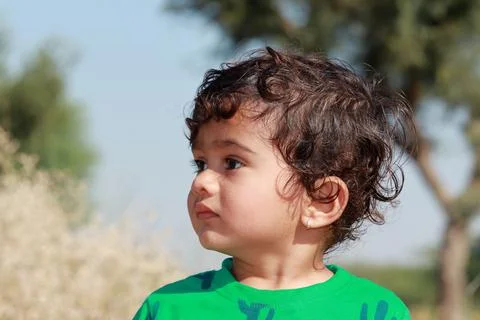 Profile view portrait of A small cute Indian Hindu child wearing a green shir Stock Photos