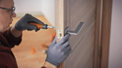 A profile view of a specialist in uniform carefully working on an interior d Stock Footage 344877403