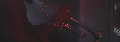 Profile view of a trumpeter playing in backlit and red neon lights Stock Footage 202319122