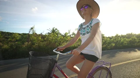 Profile wide angle backlit view of happy mature senior woman smiling biking away Stock Footage 233285631