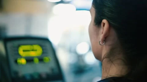 Profile of woman working out on elliptical machine at gym Stock Footage