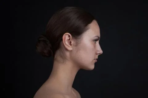 Profile of a woman's face without makeup on a black background. Stock Photos