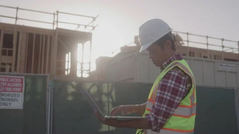Profile of Worried Contractor Looking at the Blueprints on Computer in Bright Stock Footage 208782760