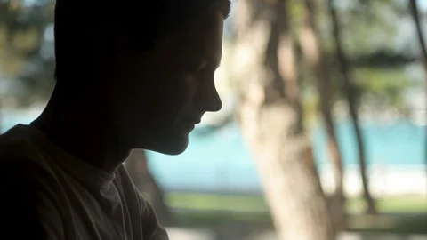 Profile of a young guy drinking water from a glass, looking out the window, coun Stock Footage 113642121