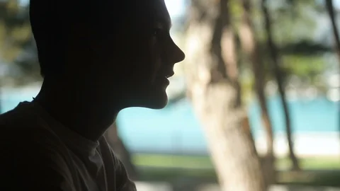 Profile of a young guy laughing and drinking water, counterlight Stock Footage 113641859