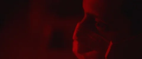 Profile of a young man putting on a protective mask, red lighting. Stock Footage 126357922