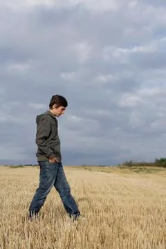 Profile of young man walking in wheat field Stock Photos