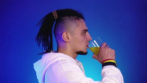 Profile of a young man in white clothes who drinks juice Vidéo 144369566