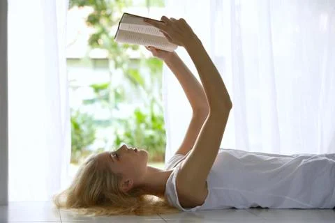 Profile of young woman reading a book Stock Photos