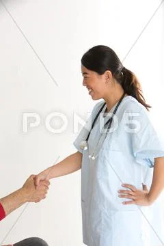 Profiled Asian Nurse Shaking Patient's Hand. Vertical Shot