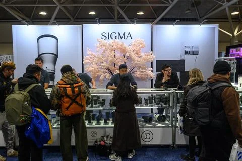 ProFusion Expo Visitors exploring camera equipment at trade show booth Stock Photos