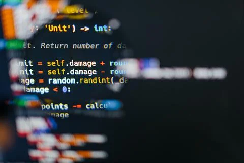 Program code on computer display in magnifying glass. Close-up. Stockfoto's