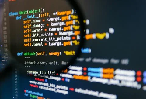 Program code on computer display in magnifying glass. Close-up. Foto stock