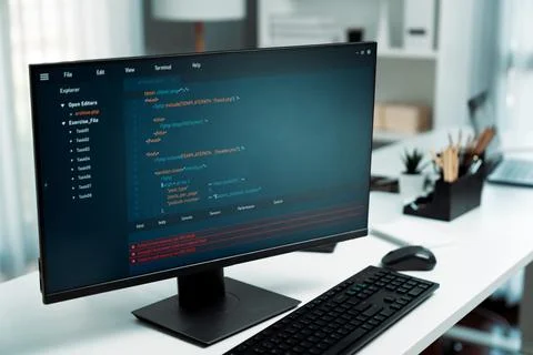 Program coding showing on pc monitor standing on desk working. Postulate. Stock Photos