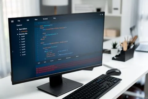 Program coding showing on pc monitor standing on desk working. Postulate. Stock Photos