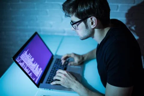 Program development concept young man working with computer in the night Foto stock