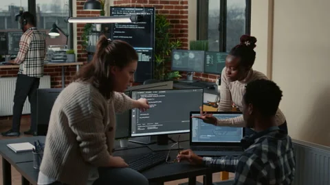 Programer sitting on desk discussing with mixed team of software developers Stock Footage 168248188