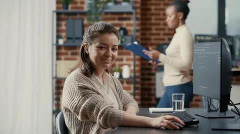 Programer typing source code on computer keyboard turning head and smiling Stock Photos