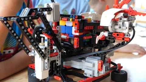 Programmed plastic robot automatics spin and folds a cube of rubik Stock Footage 90302262