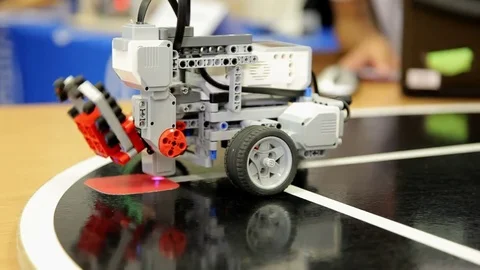 Programmed toy wagon unloads brick in the red square. Stock Footage 71422860