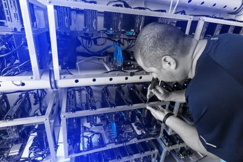 Programmer adjusting cryptocurrency mining rig Stock Photos