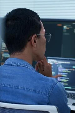 Programmer Analyzing Code on Multiple Screens Stock Photos